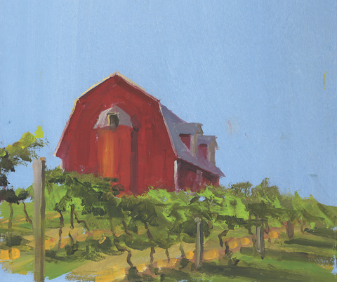 Red barn with greenery in the foreground against a blue sky