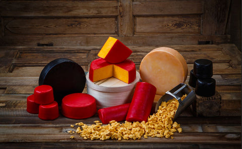 Assorted types of cheese on a wooden surface with a rustic background